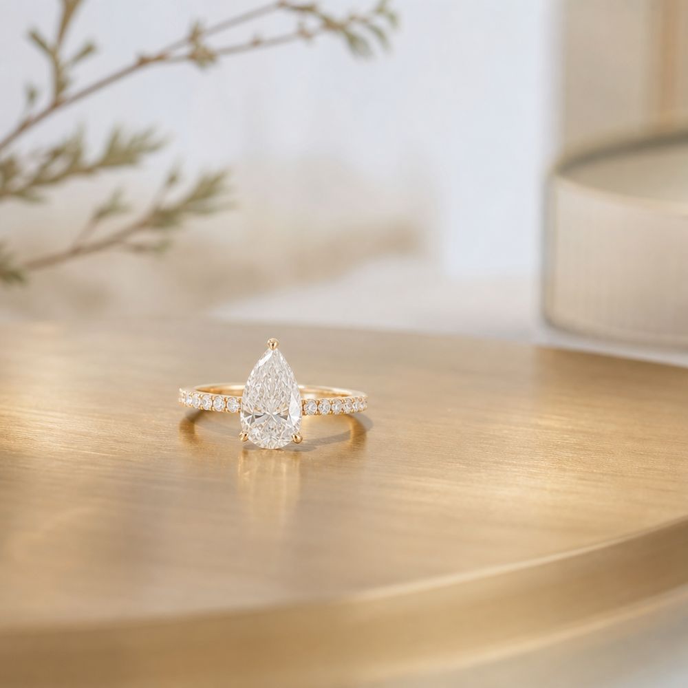 A pear diamond set low in warm gold.